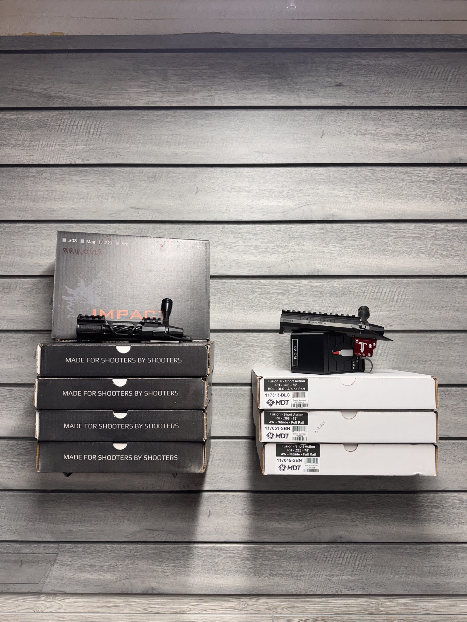 Impact Precision and MDT Fuzion actions on wall display with boxed inventory