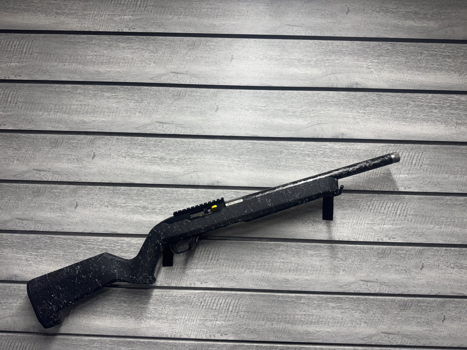 Ruger 10/22 style rifle with marbled black and white finish and threaded barrel